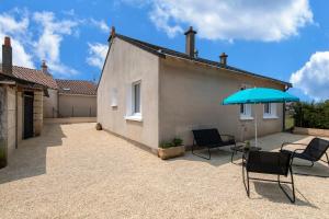 - une terrasse avec 2 chaises et un parasol bleu dans l'établissement Logis de la Perruche - Maison avec terrasses, à Montreuil-Bellay