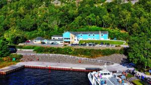 ein Boot im Wasser neben einem blauen Gebäude in der Unterkunft Loch Ness Clansman Hotel in Drumnadrochit