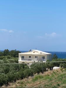 una gran casa blanca en una colina con árboles en Villa Olymp, en Nea Potidaea