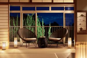dos sillas sentadas en un porche frente a una ventana en Nankishirahama Hotel Akariya, en Shirahama