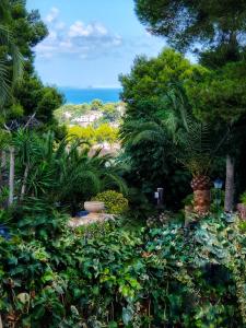 a garden with a view of the ocean at VILLA " VISTA JAVEA "- Home away from home in Jávea