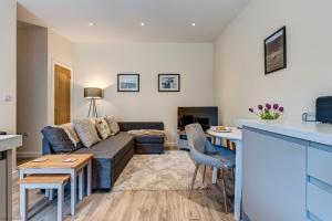 a living room with a couch and a table at Romney Barn in Minster Lovell