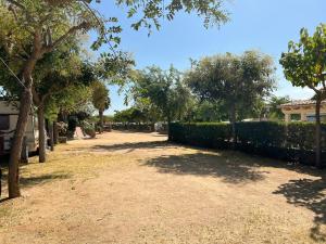 a yard with a fence and trees and a house at Camping Del Mar in Malgrat de Mar