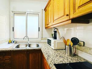 cocina con fregadero y microondas en Oyansa Apartments en Vilanova i la Geltrú