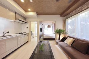 uma sala de estar com um sofá e uma cozinha em Nankishirahama Hotel Akariya em Shirahama