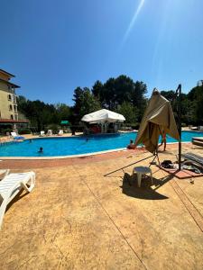 a umbrella and a chair next to a swimming pool at Summer Dreams B26 in Sunny Beach