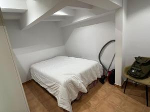 バルセロナにあるCozy Flat Barcelonaのベッドと椅子付きの小さな部屋です。