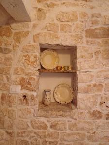 zwei Platten und eine Vase auf einer Steinmauer in der Unterkunft La Nicchia in Castellana Grotte
