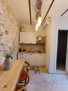 eine Küche mit einem Holztisch und einer Steinmauer in der Unterkunft La Nicchia in Castellana Grotte