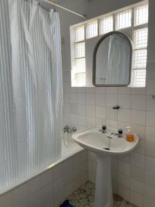 ein weißes Badezimmer mit einem Waschbecken und einem Spiegel in der Unterkunft Casa Morais in Vinhais