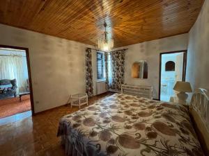 ein Schlafzimmer mit einem großen Bett und einer Holzdecke in der Unterkunft Casa Morais in Vinhais