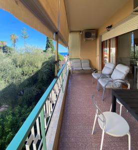 einen Balkon mit Stühlen und einem Tisch auf einem Haus in der Unterkunft Hotel Napoleon in Sanremo