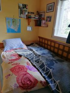 a bed with a comforter on it in a bedroom at SUNSHINE house in Orfű