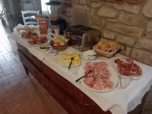 una mesa cubierta con platos de carne y pan en B&B La Rocchetta dal Sròz, en Le Serucce