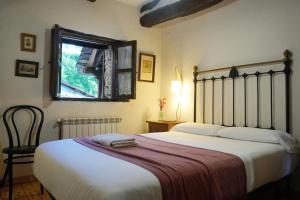 a bedroom with a large bed and a window at Fogar Mozárabe in Peñalba de Santiago