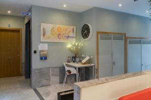 an office with a desk and a clock on the wall at Plaza de la Luz Cádiz in Cádiz