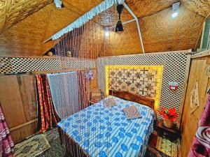 a bedroom with a bed with a blue comforter at King of kings Houseboat in Srinagar
