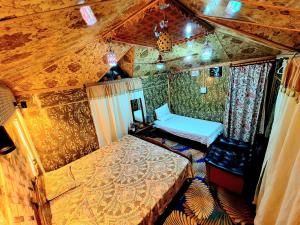 een slaapkamer met 2 bedden in een kamer met houten plafonds bij King of kings Houseboat in Srinagar