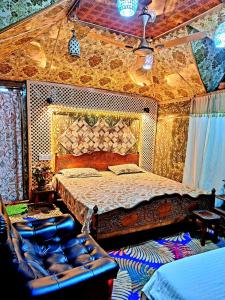 a bedroom with a bed and a couch at King of kings Houseboat in Srinagar