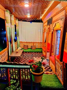 a room with a couch and a table and a pot of flowers at King of kings Houseboat in Srinagar