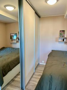 1 dormitorio con 1 cama y pared de cristal en Modern apartment in Tromsø, en Tromsø