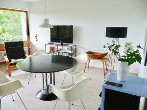 ein Wohnzimmer mit einem Tisch und Stühlen sowie einem TV in der Unterkunft Haus am See in Illmensee