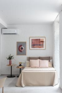 a white bedroom with a bed and a white brick wall at VLC Host - Harbor Seaside in Valencia