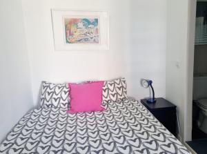 リスボンにあるThe New Terrace Lisbonのベッドルーム1室(ピンクの枕付きのベッド1台付)