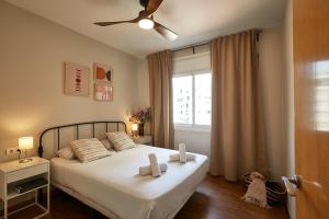 バルセロナにあるBBarcelona Marina Flatのベッドルーム1室(白いシーツ付きのベッド1台、窓付)