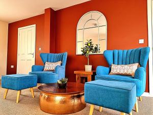 a living room with two blue chairs and a table at Detached House with Free Parking Long Stay Discounts in Thurcaston