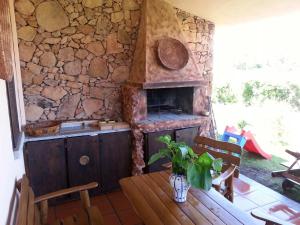 eine Küche mit Steinwänden, einem Tisch und einem Steinofen in der Unterkunft Case Vacanza Cala Paradiso in San Teodoro