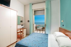 a bedroom with a bed and a view of the ocean at Hotel Odeon in Cervia