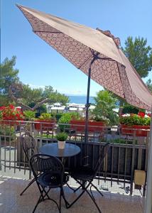 una mesa y sillas con una sombrilla en el balcón en Hotel Serena, en Arenzano