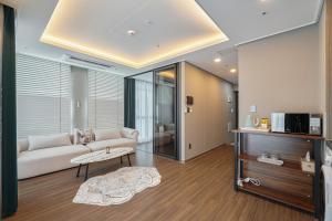 Sienna Ambassador Residence في بوسان: غرفة معيشة مع أريكة وطاولة