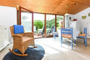 a living room with wicker chairs and a table at Ferienhaus Nordseeschnecke in Bensersiel