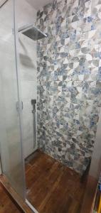 a shower with a glass door and a tile wall at Акварелі 2 in Vyshneve