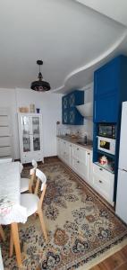 a kitchen with blue and white cabinets and a table at Акварелі 2 in Vyshneve