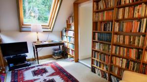 a room with two large book shelves filled with books at Glen Cottage in Comrie