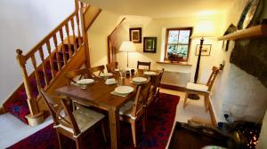 a dining room with a wooden table and chairs at Glen Cottage in Comrie