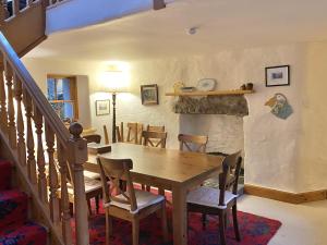 a dining room with a wooden table and a fireplace at Glen Cottage in Comrie