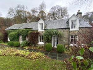 an old stone house with ivy at Glen Cottage in Comrie