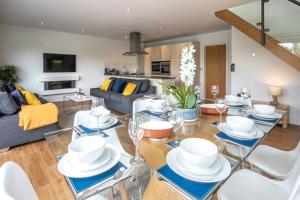 uma sala de estar com uma mesa com pratos e copos de vinho em Waters Edge 04, Waterside Lodge P em South Cerney