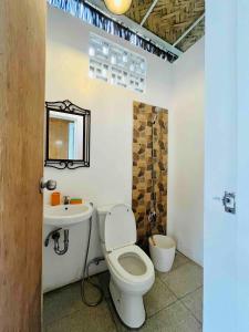 a bathroom with a toilet and a sink at Kaha Briones Family Guest House in Tarlac