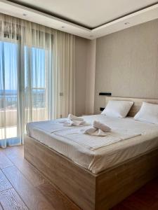 a bedroom with a large bed and a large window at Perla apartmani in Petrovac na Moru