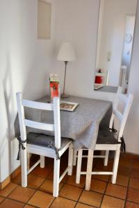uma mesa de jantar com 2 cadeiras brancas e uma mesa com uma mesa em Gut Basthorst em Basthorst