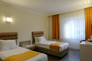 een hotelkamer met 2 bedden en een raam bij Anatolia Park Hotel in Kayseri