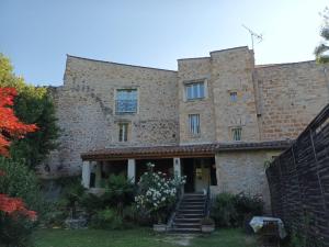 an old stone building with stairs in a yard at Maison d'Hotes Le Val d'Aleth in Alet-les-Bains