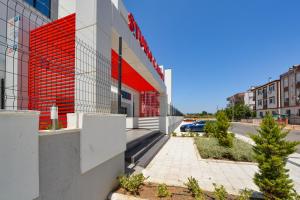 a building with a red wall on a street at C Suites Antalia in Antalya