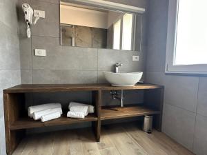 a bathroom with a sink and a mirror and towels at 88 Miglia in La Spezia