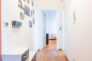 ミラノにあるIntero alloggio M3 Porta Romanaの白い壁とウッドフロアの廊下が備わる客室です。